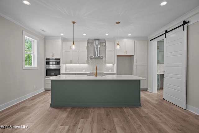 629 Vale Dr, Wilmington, NC 28411 - kitchen featuring wall chimney range hood, stainless steel double oven, a barn door, baseboards, and white cabinets