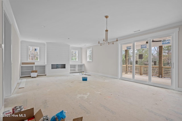 unfurnished living room with ornamental molding, a glass covered fireplace, visible vents, and a notable chandelier
