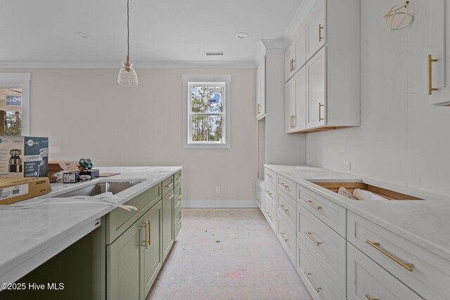 kitchen featuring pendant lighting, light stone counters, crown molding, and green cabinets