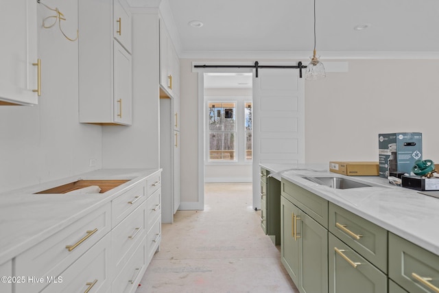 kitchen featuring crown molding, white cabinetry, light stone countertops, green cabinetry, and a barn door