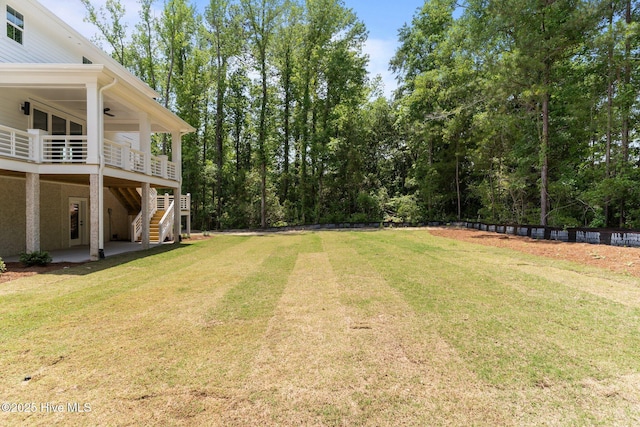 629 Vale Dr, Wilmington, NC 28411 - view of green lawn featuring a ceiling fan, stairs, and a wooden deck