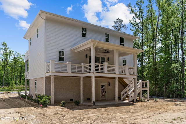 rear view of property with a ceiling fan, a wooden deck, and stairs