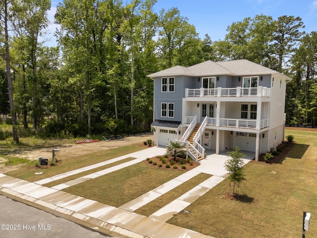 629 Vale Dr, Wilmington, NC 28411 - raised beach house with a garage, a balcony, driveway, a front yard, and stairway