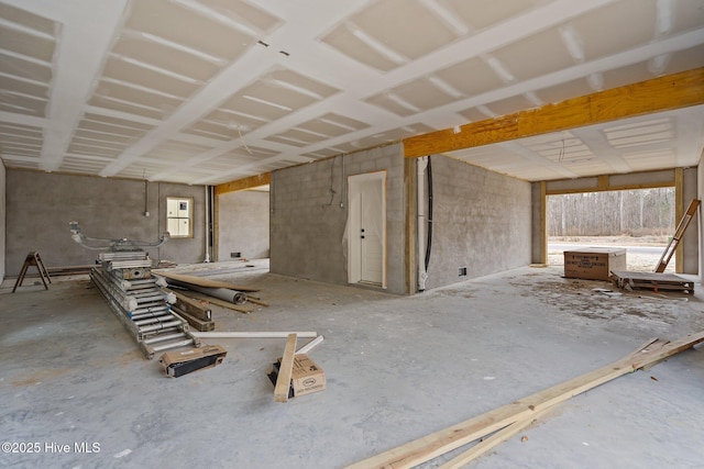 misc room with a healthy amount of sunlight, concrete floors, and electric panel