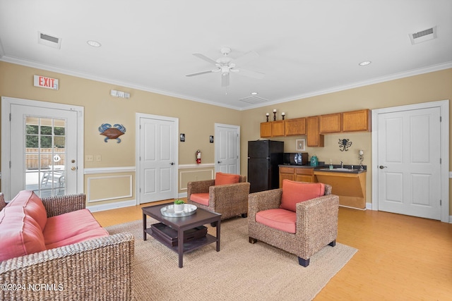 living room with sink, ornamental molding, light hardwood / wood-style floors, and ceiling fan