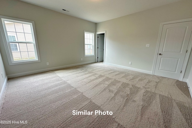 carpeted empty room with a wealth of natural light