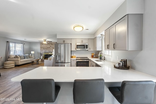 kitchen featuring sink, stainless steel appliances, a breakfast bar, and kitchen peninsula