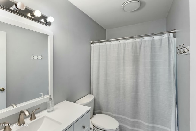 bathroom with a shower with shower curtain, vanity, and toilet