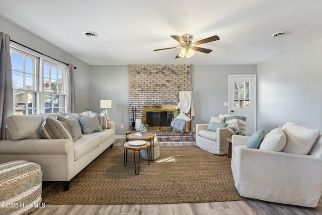 living room with a fireplace, ceiling fan, and hardwood / wood-style flooring