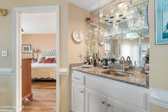 bathroom with wood-type flooring, vanity, a textured ceiling, and vaulted ceiling