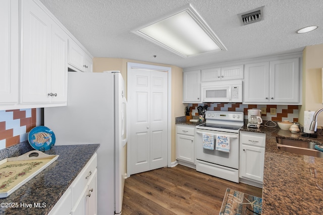 kitchen featuring white appliances, a textured ceiling, dark hardwood / wood-style flooring, white cabinets, and sink