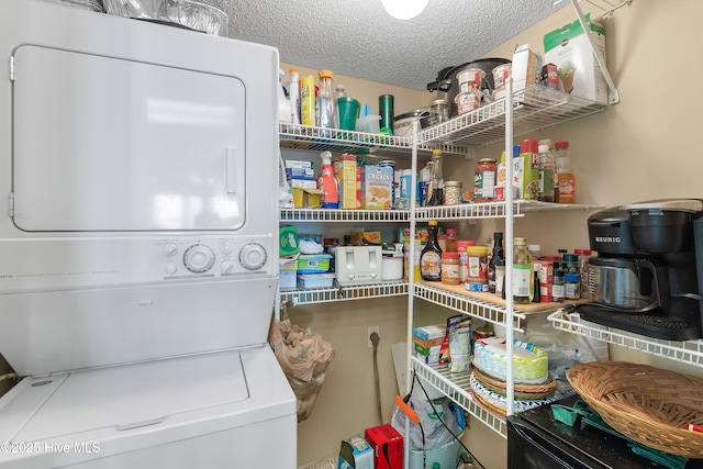 pantry featuring stacked washer / dryer