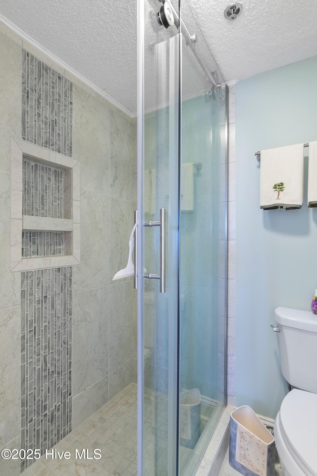 bathroom with toilet, a textured ceiling, and walk in shower