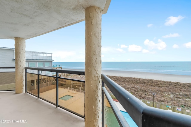 balcony featuring a water view and a view of the beach