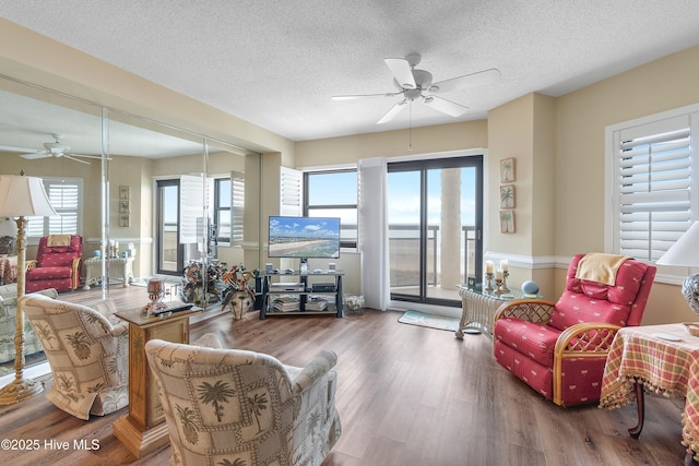 living room with a textured ceiling, a wealth of natural light, and hardwood / wood-style flooring