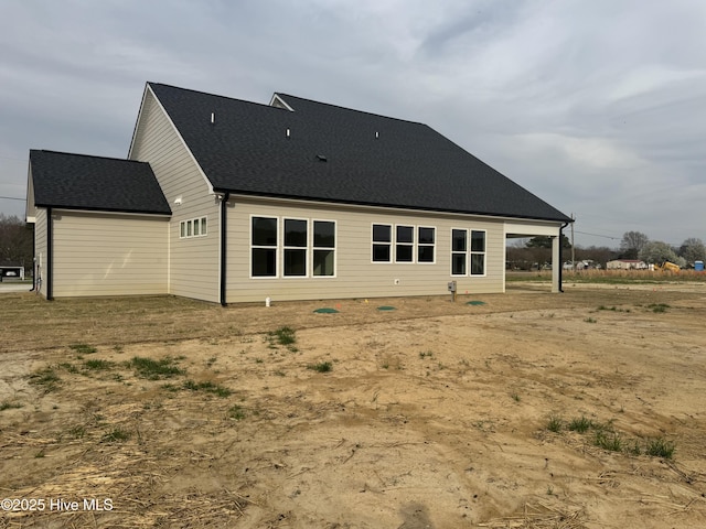 rear view of house featuring a shingled roof