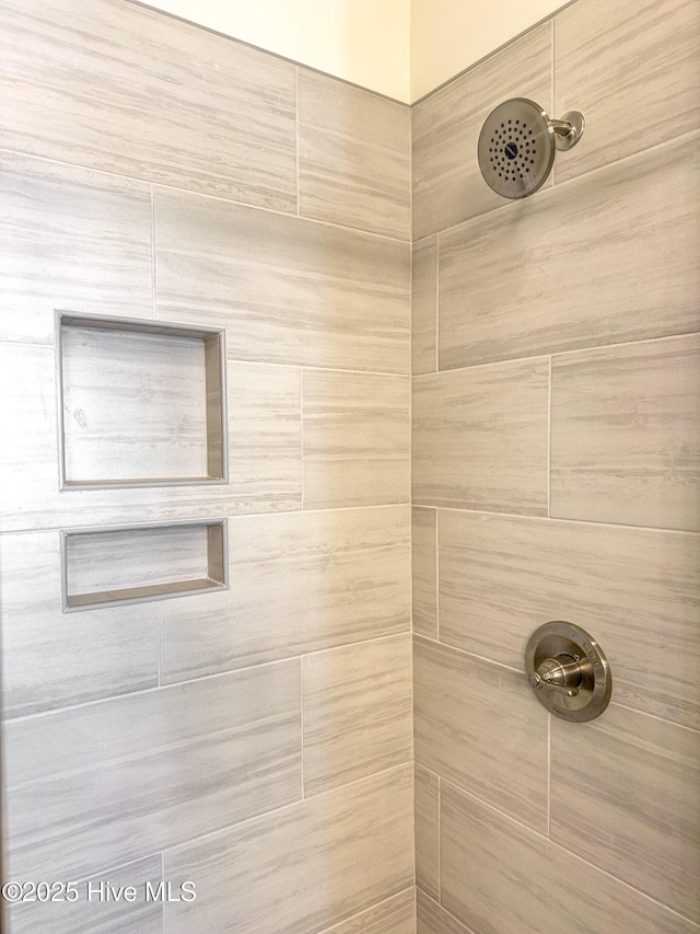 interior details featuring a tile shower