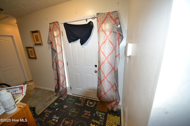 foyer entrance with a textured ceiling