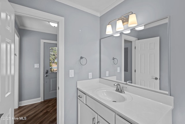 bathroom featuring ornamental molding, vanity, baseboards, and wood finished floors