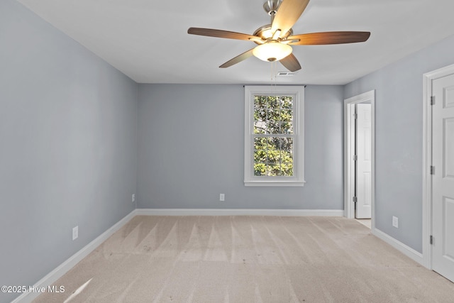 unfurnished room featuring a ceiling fan, light carpet, and baseboards