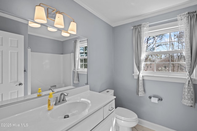 bathroom with plenty of natural light, vanity, toilet, and crown molding