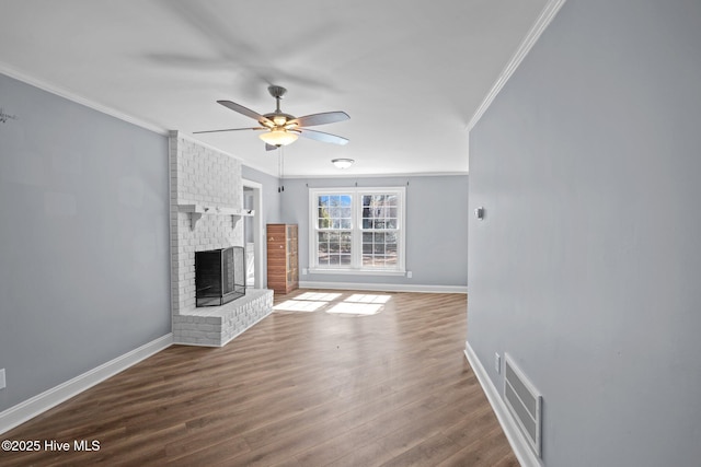 unfurnished living room featuring crown molding, visible vents, a fireplace, and wood finished floors