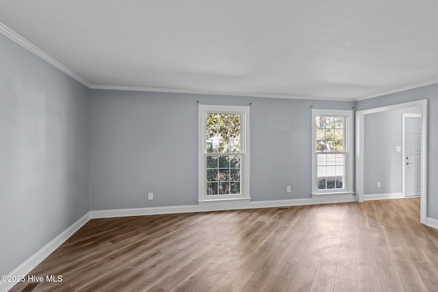 unfurnished room with crown molding, wood finished floors, and baseboards