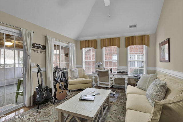 living room with ceiling fan, plenty of natural light, lofted ceiling, and wood-type flooring