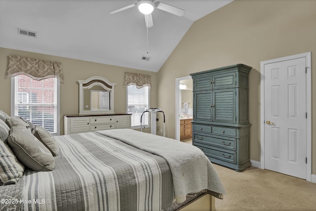 bedroom featuring ceiling fan, ensuite bath, lofted ceiling, and light carpet