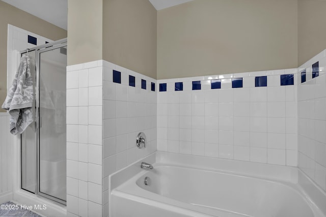 bathroom featuring shower with separate bathtub