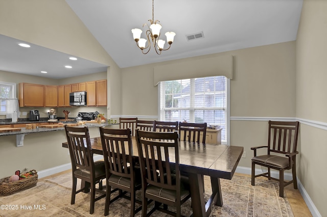 dining area with high vaulted ceiling and a notable chandelier