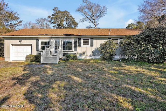 back of property with a garage and a lawn