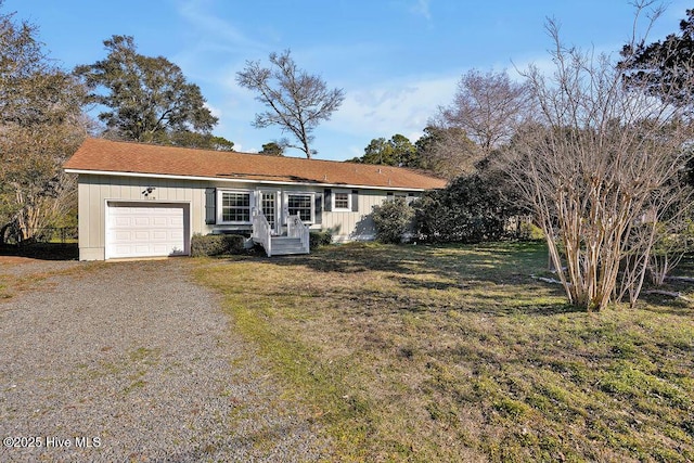 ranch-style house featuring a garage and a front lawn