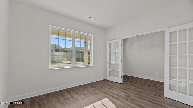 spare room with hardwood / wood-style floors and french doors