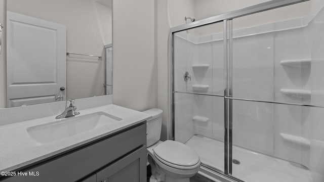 bathroom featuring vanity, toilet, and a shower with shower door