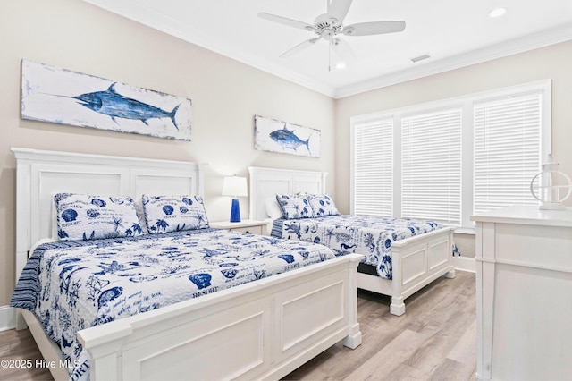 bedroom featuring ceiling fan, light wood-type flooring, and crown molding