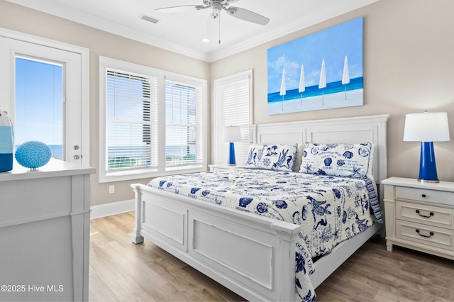 bedroom featuring ceiling fan, ornamental molding, and light hardwood / wood-style flooring