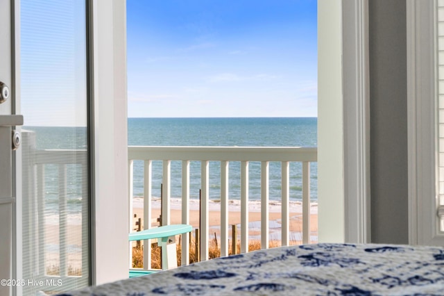 unfurnished bedroom featuring a water view and a view of the beach