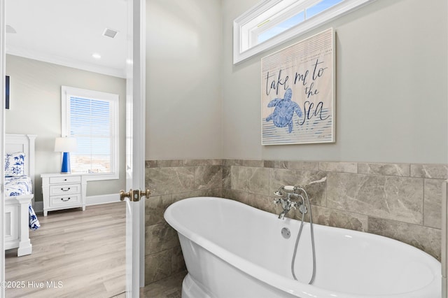 bathroom with hardwood / wood-style floors and a tub to relax in