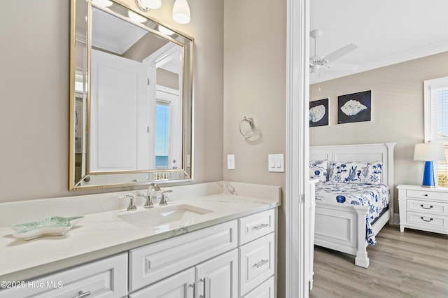 bathroom with ceiling fan, vanity, crown molding, and hardwood / wood-style flooring