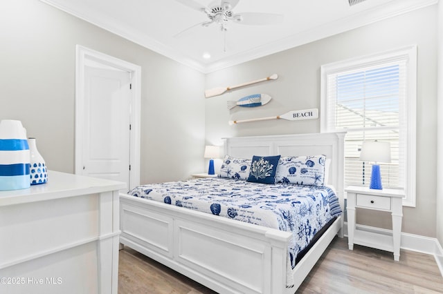 bedroom with ceiling fan, crown molding, and hardwood / wood-style flooring