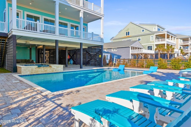 view of swimming pool featuring an in ground hot tub and a patio area