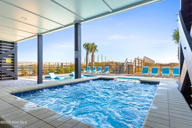 view of swimming pool with a water view and a hot tub