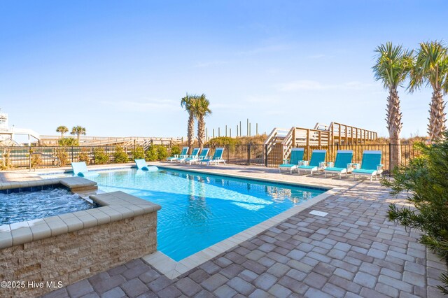 view of pool with an in ground hot tub and a patio