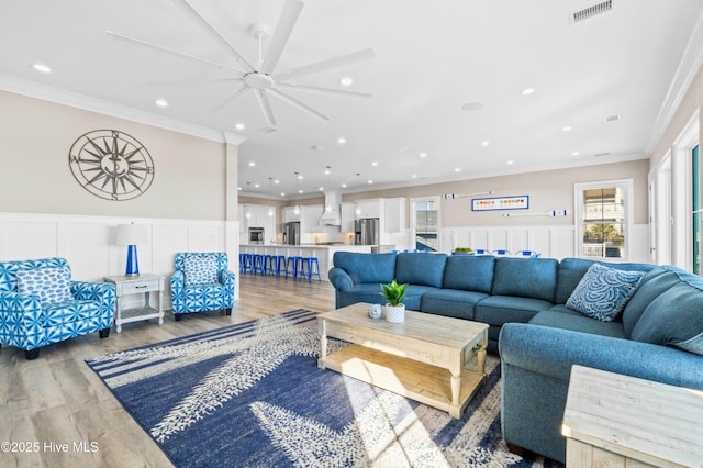 living room with ceiling fan, crown molding, and hardwood / wood-style floors