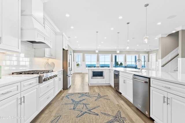 kitchen with stainless steel appliances, decorative backsplash, pendant lighting, white cabinets, and sink