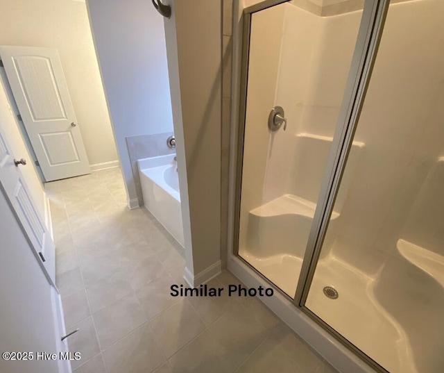 bathroom featuring plus walk in shower and tile patterned flooring