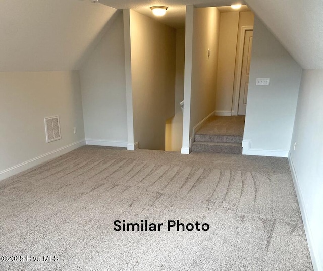 bonus room with carpet and vaulted ceiling