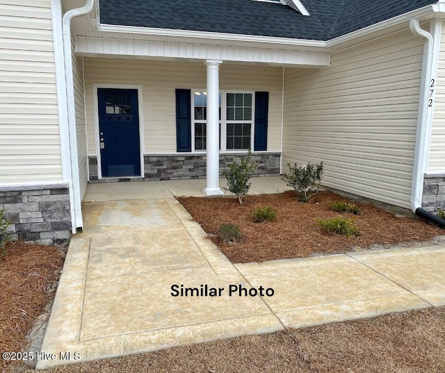 view of exterior entry featuring covered porch