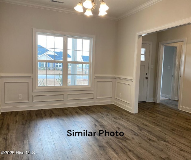 unfurnished dining area with dark wood-type flooring, crown molding, and a chandelier